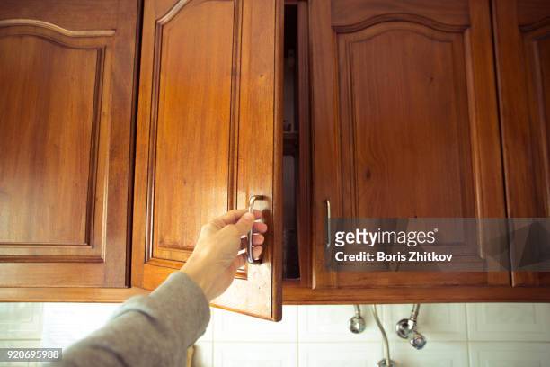 man opens the cabinet door - armário de cozinha imagens e fotografias de stock
