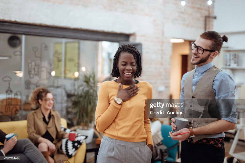 Dos colegas con refrigerio en el salón