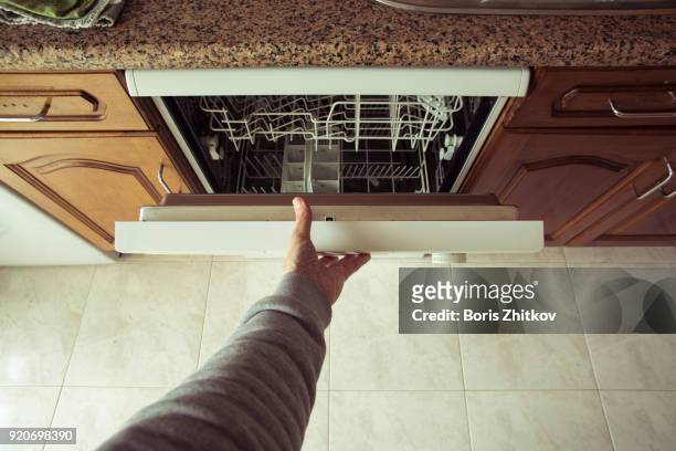 man opens the dishwasher - dishwasher stock pictures, royalty-free photos & images