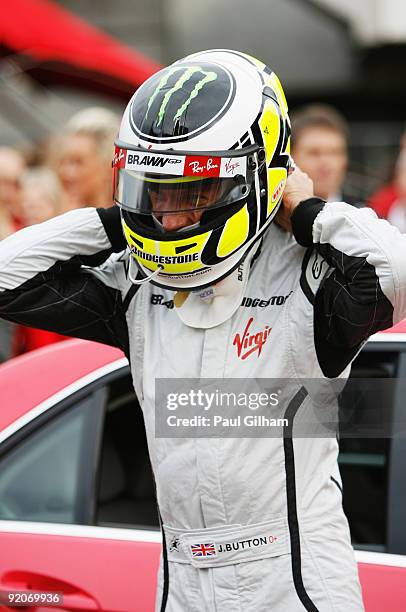 New Formula One World Champion Jenson Button of Great Britain and Brawn GP prepares to take competition winners for a drive following a Virgin...