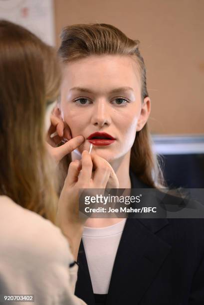Model has makeup applied backstage ahead of the Paula Knorr Presentation during London Fashion Week February 2018 at BFC Show Space on February 19,...