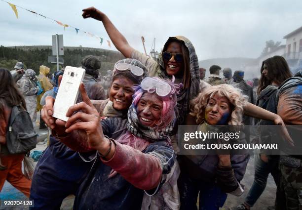 Revellers take selfies as they partcipate in a 'flour war' during 'Ash Monday' celebrations, a traditional festivity marking the end of the carnival...