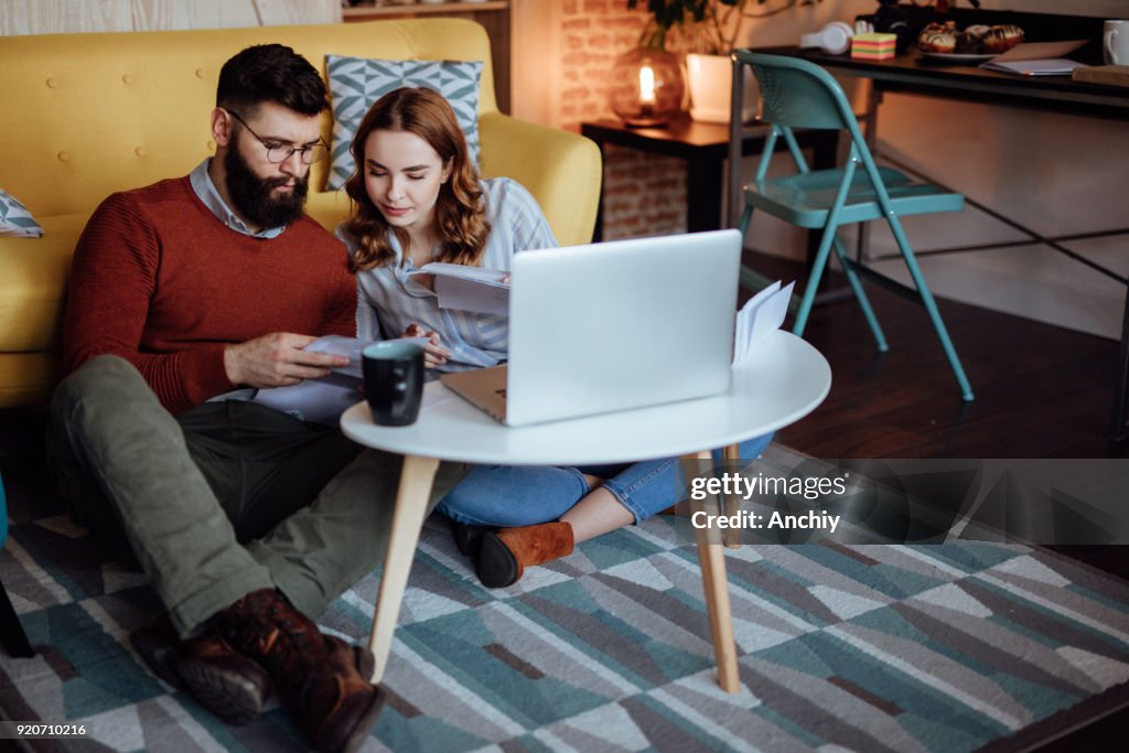 Young couple looking trough mail expecting new orders