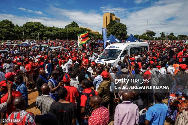 Mourners wave good bye as the hearse carrying Morgan Tsvangirai passes through supporters of the Movement for Democratic Change party gathered at...