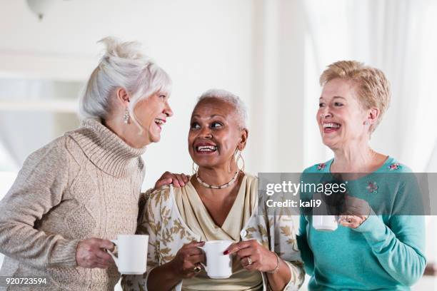 three multi-ethnic senior women socializing over coffee - female with friend in coffee stock pictures, royalty-free photos & images