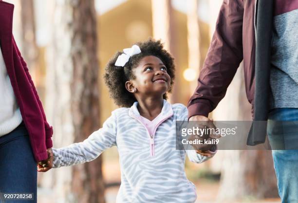 little girl walking with family, looking at father - midsection stock pictures, royalty-free photos & images