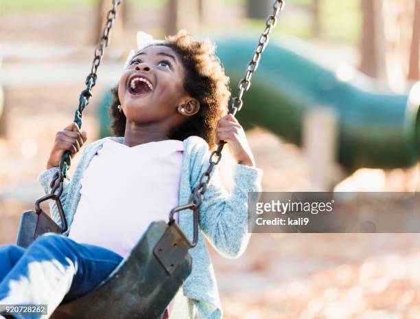 afro-amerikaanse meisje op een schommel - girl in black jeans stockfoto's en -beelden
