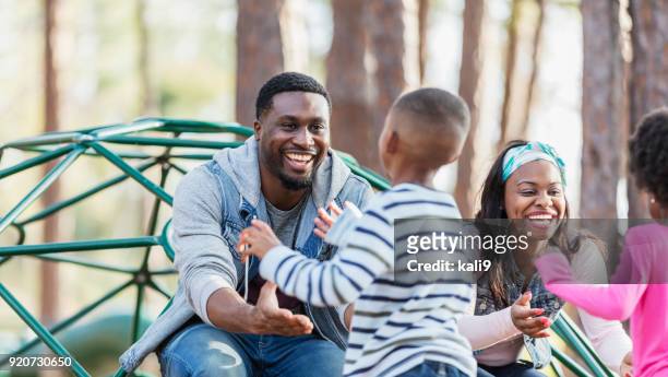 african-american family with two children on playground - child boy arms out stock pictures, royalty-free photos & images