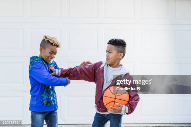 two boys with basketball, sibling rivalry - sibling fight stock pictures, royalty-free photos & images