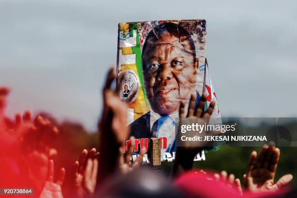 Supporters of the Movement for Democratic Change holds up a poster bearing a portrait of Zimbabwe's iconic opposition leader Morgan Tsvangirai who...