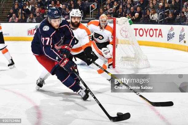 Josh Anderson of the Columbus Blue Jackets skates and Radko Gudas of the Philadelphia Flyers battle for control of the puck on February 16, 2018 at...