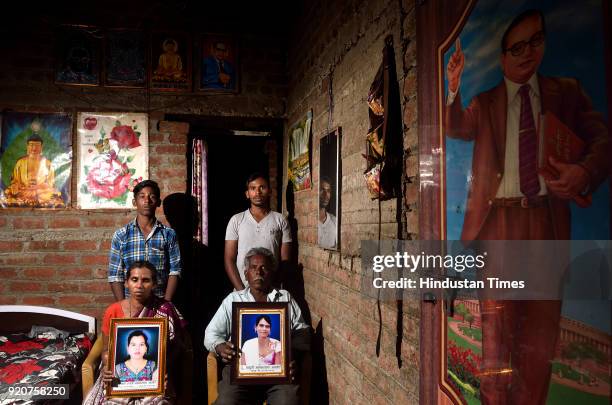 Bhaskar Asode and Devku Asode with sons Rahul and Sagar hold the picture of their two young daughters who committed suicide by consuming pesticide in...