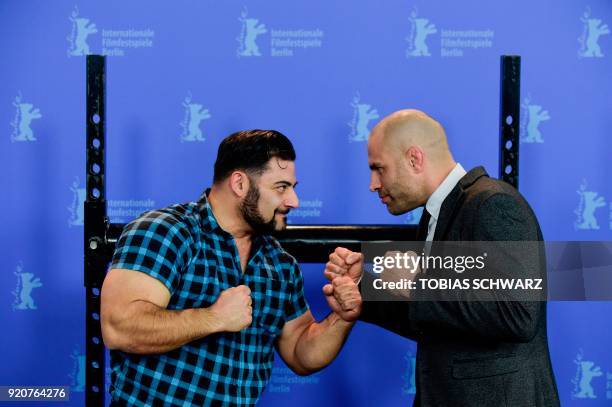 Protagonist German strongman competitor, strength athlete and former bodybuilder Patrik Baboumian poses with protagonist retired English professional...