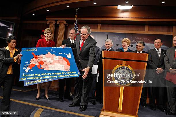 Sen. Tom Harkin gets a hand with some posters during a news conference with fellow Senate Democrats about extending unemployment benefits at the U.S....