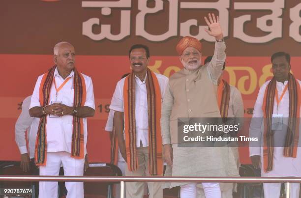 Prime Minister Narendra Modi waves as BJP state president and Chief Minister candidate Yeddyurappa looks on during a political rally at Maharaja...