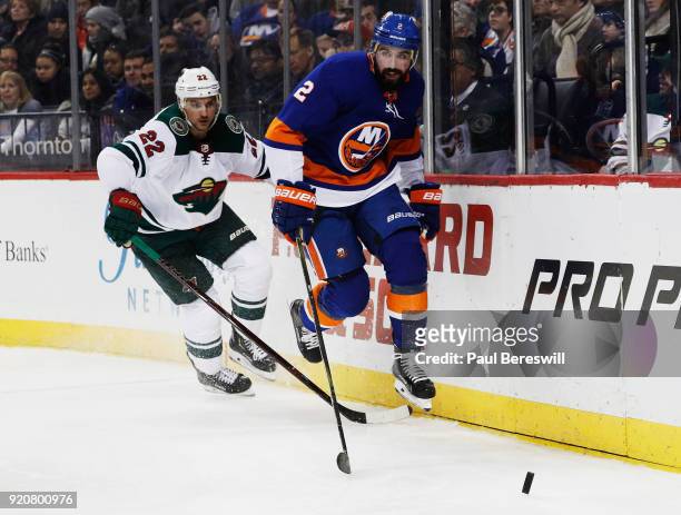Nick Leddy of the New York Islanders and Nino Niederreiter of the Minnesota Wild chase down a loose puck during the second period at Barclays Center...