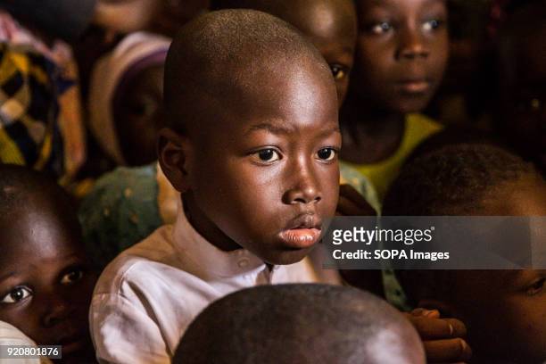 Young Ghanaian boy looks on longingly as sweets are given out to children in the remote village of Kpalong. Kpalong is 50kms outside Tamale in...