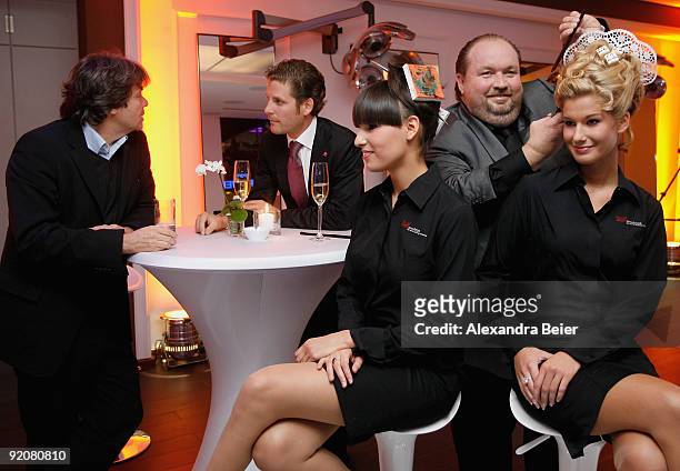 Munich's prominent hairdresser Wolfgang Lippert poses with two models as event manager Philip Greffenius and caterer Michael Kaefer watch them during...