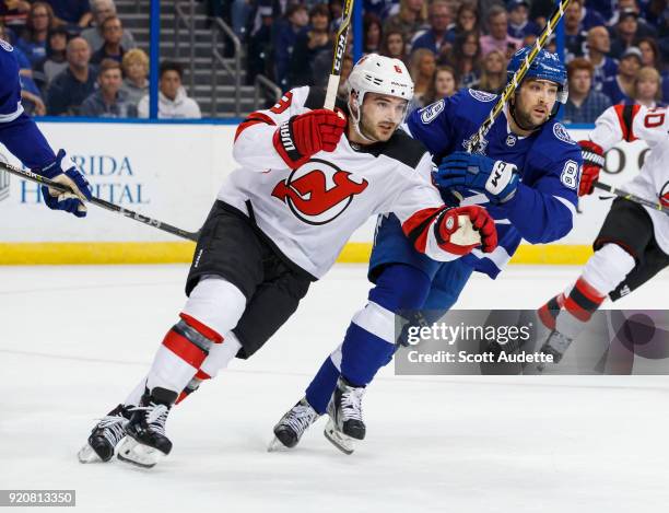 Cory Conacher of the Tampa Bay Lightning skates against Will Butcher of the New Jersey Devils during the first period at Amalie Arena on February 17,...