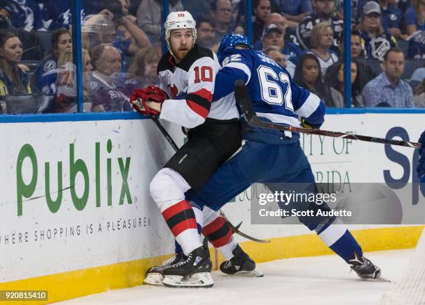 Andrej Sustr of the Tampa Bay Lightning skates against Jimmy Hayes of the New Jersey Devils during the second period at Amalie Arena on February 17,...
