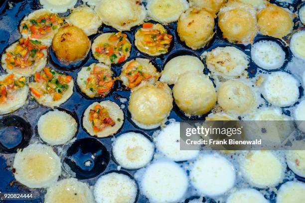 Fried small eggs, a popular snack, are displayed for sale at a street restaurant.