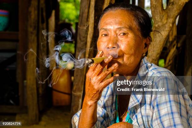 Portrait of a woman smoking a Cheerot, a local cigar.