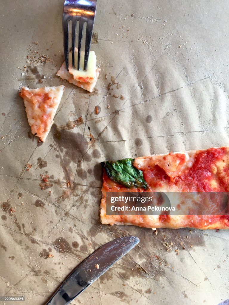 Overhead shot of slice of pizza with fork and knife