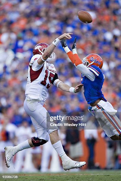 Ryan Mallett of the Arkansas Razorbacks has his pass tipped by Joe Haden of the Florida Gators at Ben Hill Griffin Stadium on October 17, 2009 in...