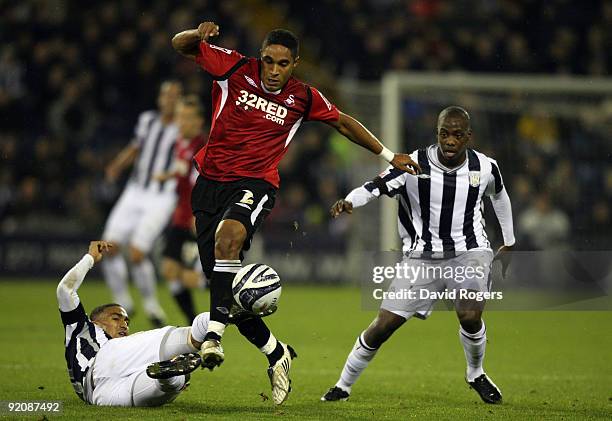 Ashley Williams of Swansea City is tackled by Gianni Zuiverloon and Youssouf Mulumbu and during the Coca- Cola Championship match between West...