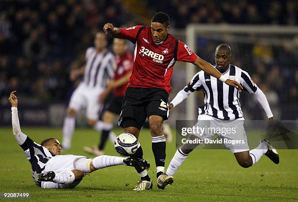Ashley Williams of Swansea City is tackled by Gianni Zuiverloon and Youssouf Mulumbu and during the Coca- Cola Championship match between West...