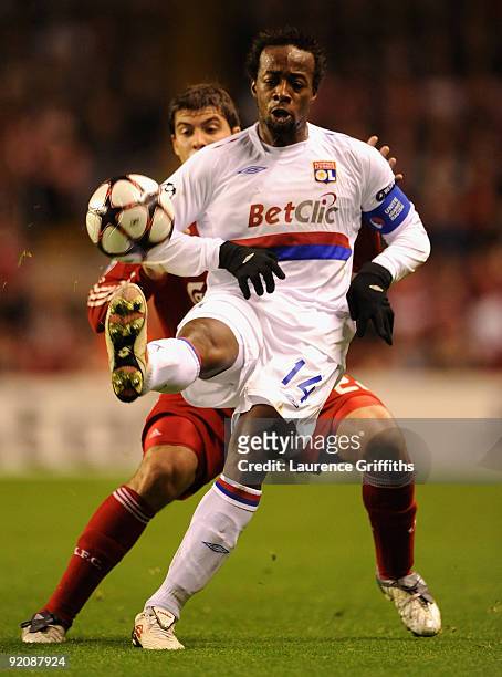 Sidney Govou of Lyon battles with Emiliano Insua of Liverpool during the UEFA Champions League Group E match between Liverpool and Lyon at Anfield on...