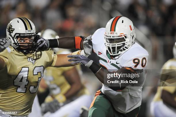 Defensive end Steven Wesley of the Miami Hurricanes battles running back Ricky Ray of the Central Florida Knights at Bright House Networks Stadium on...