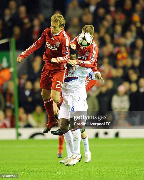 Lucas and Fabio Aurelio of Liverpool battle with Sidney Govou of Lyon during the UEFA Champions League group E match between Lyon and Liverpool at...