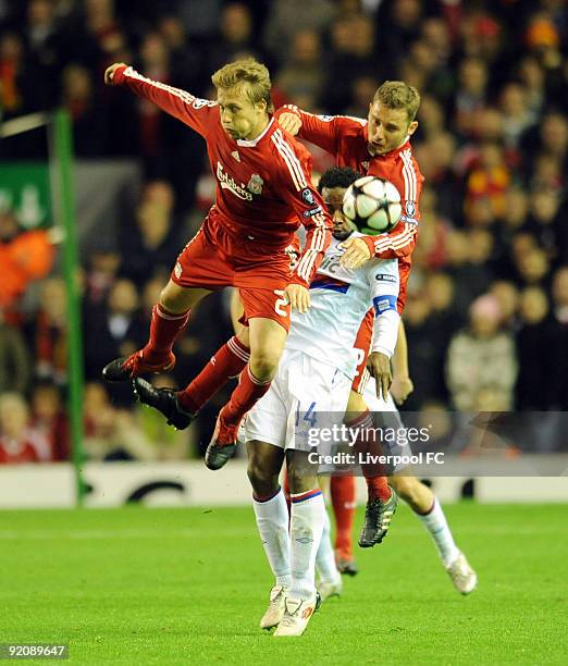 Lucas and Fabio Aurelio of Liverpool battle with Sidney Govou of Lyon during the UEFA Champions League group E match between Lyon and Liverpool at...