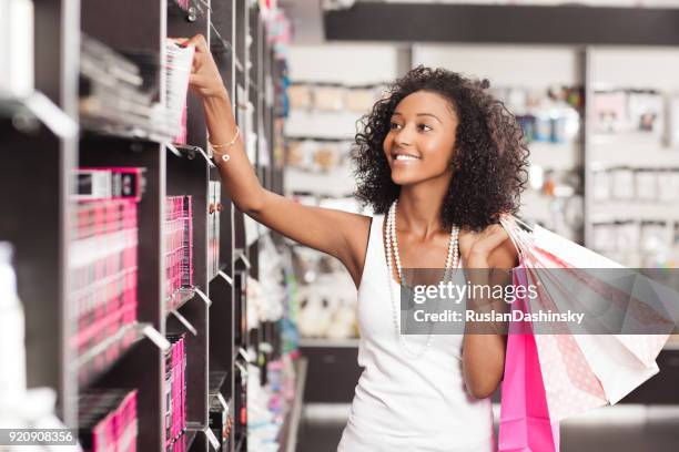 mooie jonge vrouw winkelen cosmetica. - beauty shopping stockfoto's en -beelden