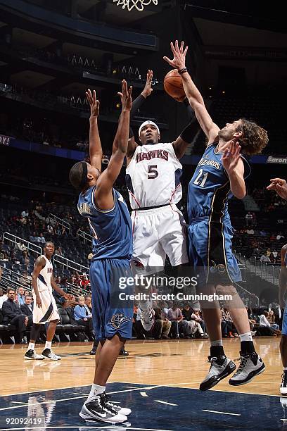 Josh Smith of the Atlanta Hawks goes to the basket under pressure against Dominic McGuire and Fabricio Oberto of the Washington Wizards during the...