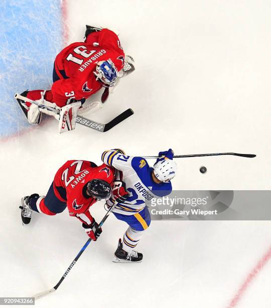 Kyle Okposo of the Buffalo Sabres looks to shoot on net as Madison Bowey and Philipp Grubauer of the Washington Capitals defend net during an NHL...