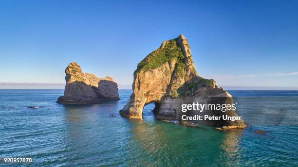 archway islands at wharariki beach,cape farewell, tasman, new zealand - peter nelson stock pictures, royalty-free photos & images