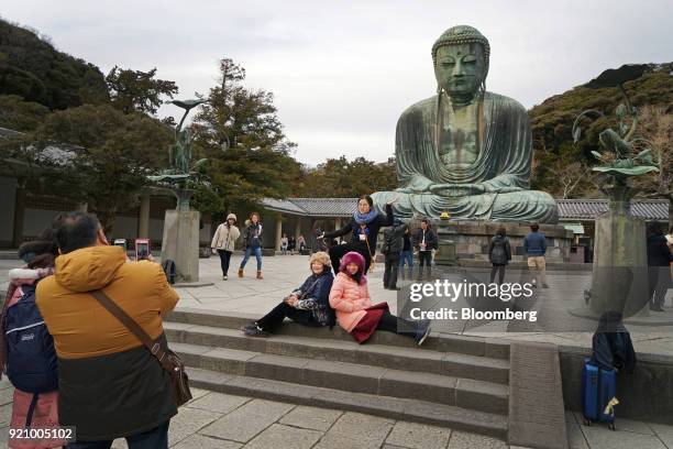 Tourists take photographs with their smartphones in front of the Great Buddha at the Kotokuin temple in Kamakura, Kanagawa, Japan, on Monday, Feb....