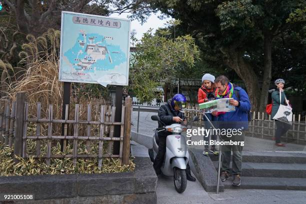 Tourists, right, ask a motorist for directions outside of the Kotokuin temple in Kamakura, Kanagawa, Japan, on Monday, Feb. 19, 2018. The Japan...