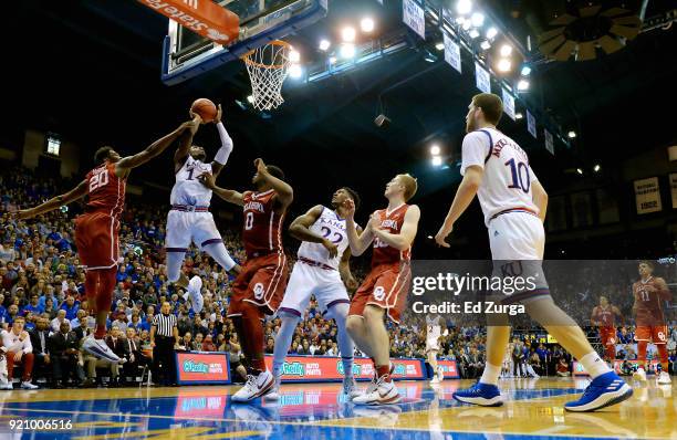 Malik Newman of the Kansas Jayhawks shoots between Kameron McGusty and Christian James of the Oklahoma Sooners in the first half at Allen Fieldhouse...