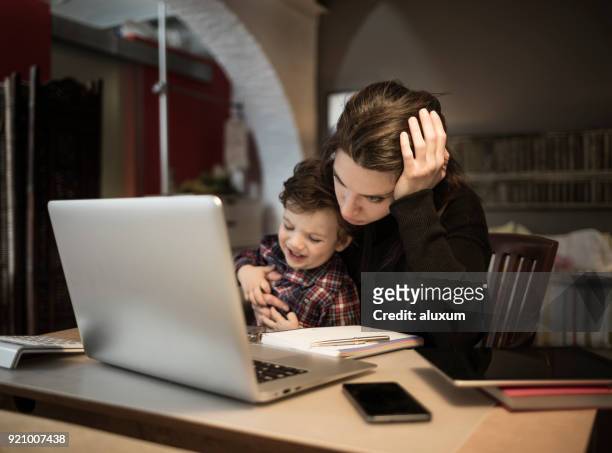 mujer preocupada por trabajar en casa y que a su pequeño hijo llorando - presión fotografías e imágenes de stock
