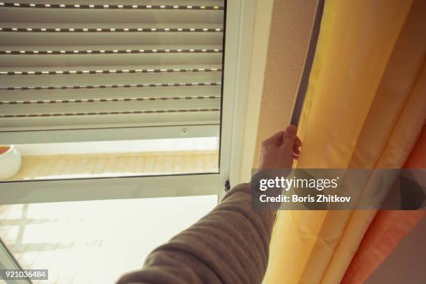 male hand closing rolling shutter - fensterladen stock-fotos und bilder