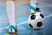 Indoor soccer sports player with ball. Football futsal player, ball, futsal floor. Sports background. Youth futsal league. Indoor football players with classic soccer ball.