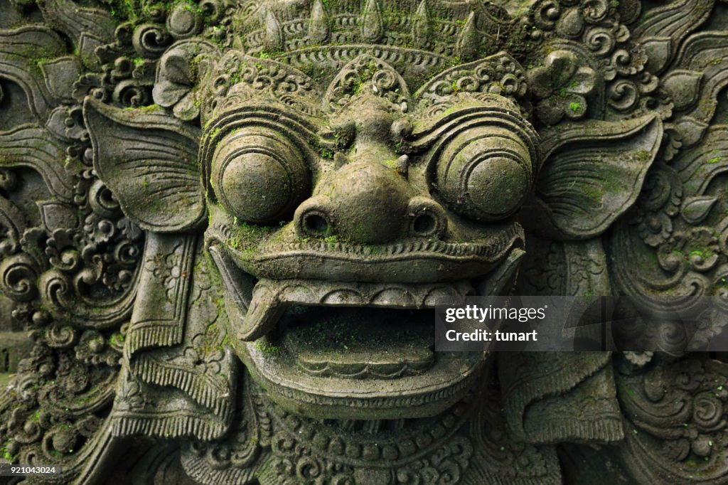 Close-up of Barong Lion Guard's Face, Mossy Statue of Balinese Mythological Hero Carved From Stone