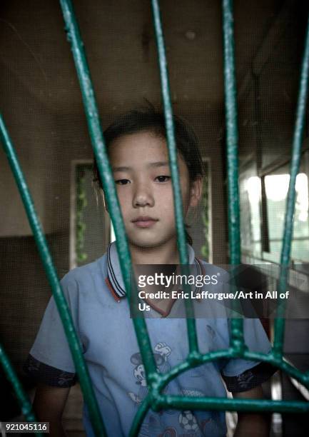 Portrait of a North Korean girl behind the bars of a window, Kangwon Province, Chonsam Cooperative Farm, North Korea on September 10, 2008 in Chonsam...