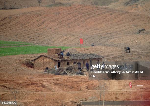 North horean men making a straw roof in the countryside, Pyongan Province, Pyongyang, North Korea on April 30, 2010 in Pyongyang, North Korea.