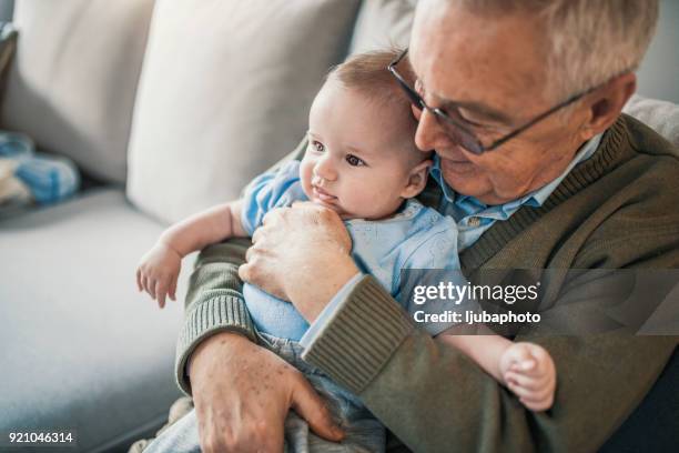 grandparent holding baby boy on lap - baby grandpa imagens e fotografias de stock