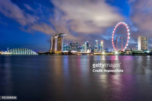 reflection of marina bay and singapore flyer at twilight, singapore - impossiable fotografías e imágenes de stock