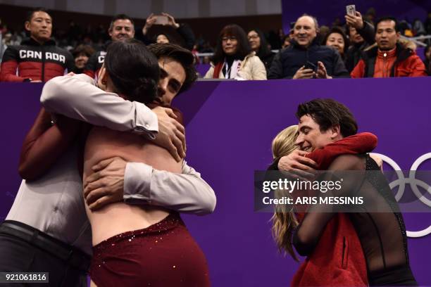 Canada's Tessa Virtue and Canada's Scott Moir hug compatriots Canada's Kaitlyn Weaver and Canada's Andrew Poje following the former's gold win in the...